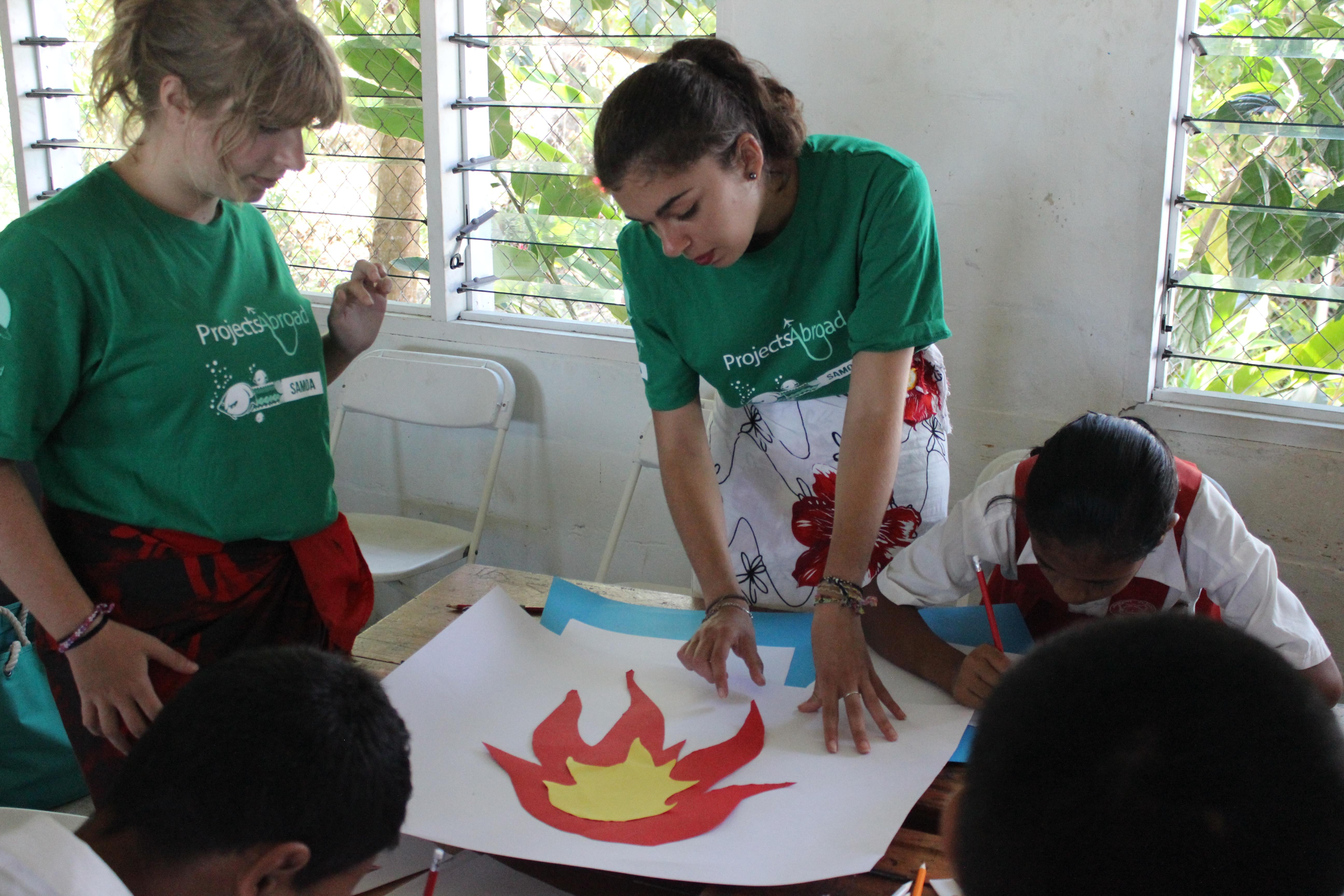 Projects Abroad volunteers teach children at local school during their cultural immersion in Samoa. Volunteers in a village in Samoa teach children at a local school.